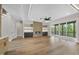 Open-concept living room with hardwood floors, fireplace, built-in shelves, and sliding glass doors at 205 Red Cardinal Ct, Youngsville, NC 27596