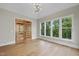 Bright room boasts hardwood floors, stylish light fixture, and a wall of windows offering scenic views at 205 Red Cardinal Ct, Youngsville, NC 27596