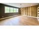 Spacious living room featuring hardwood floors, large windows, and a unique wood accent wall at 205 Red Cardinal Ct, Youngsville, NC 27596