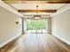 Open living space features hardwood floors, wooden beam ceiling and glass sliding doors to a deck at 205 Red Cardinal Ct, Youngsville, NC 27596