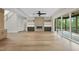 A bright, open-concept living room with hardwood floors, fireplace, built-in shelves, and sliding glass doors at 205 Red Cardinal Ct, Youngsville, NC 27596