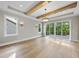 Living room featuring hardwood floors, exposed beams, modern light fixture, and sliding glass doors to a deck at 205 Red Cardinal Ct, Youngsville, NC 27596