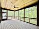 Spacious screened-in porch with wood flooring, ceiling fan, and peaceful views of surrounding greenery at 205 Red Cardinal Ct, Youngsville, NC 27596