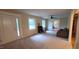 Open living room with neutral carpet, bright windows, and a ceiling fan at 7610 Buckhorn Rd, Hillsborough, NC 27278