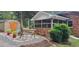 Backyard patio area featuring a bench and two blue chairs, screened porch and storage shed at 7610 Buckhorn Rd, Hillsborough, NC 27278