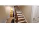 Hardwood staircase leading to the upper level, adjacent to a bathroom at 7610 Buckhorn Rd, Hillsborough, NC 27278