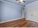Spacious bedroom with light blue walls, wood floors and double doors to closet at 6720 Fawn Hoof Trl, Holly Springs, NC 27540