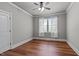 Gray bedroom with wood floors, ceiling fan and window with sheer curtains at 6720 Fawn Hoof Trl, Holly Springs, NC 27540