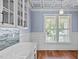 Dining area with hardwood floors, white cabinets, and blue walls at 6720 Fawn Hoof Trl, Holly Springs, NC 27540