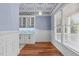 Dining room with hardwood floors, white cabinets, and blue walls at 6720 Fawn Hoof Trl, Holly Springs, NC 27540