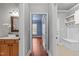 Hallway with light gray walls, wood floors and access to laundry and bedroom at 6720 Fawn Hoof Trl, Holly Springs, NC 27540