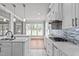 Bright kitchen with white cabinets, a gas cooktop, and a view of the backyard at 6720 Fawn Hoof Trl, Holly Springs, NC 27540