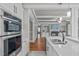 Modern kitchen featuring double ovens, a farmhouse sink, and hardwood floors at 6720 Fawn Hoof Trl, Holly Springs, NC 27540