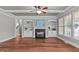 Spacious living room with hardwood floors, fireplace, built-in shelving, and ceiling fan at 6720 Fawn Hoof Trl, Holly Springs, NC 27540