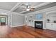 Living room featuring hardwood floors, fireplace, built-in shelving and a ceiling fan at 6720 Fawn Hoof Trl, Holly Springs, NC 27540