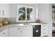 Modern kitchen features ample natural light, white cabinets and light stone countertops at 712 Daniels St, Raleigh, NC 27605