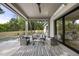 Spacious covered patio with comfortable seating, ceiling fan, and scenic views of the backyard pool at 712 Daniels St, Raleigh, NC 27605