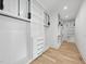 Bright walk-in closet boasts custom shelves, drawers, and black hardware on a light hardwood floor at 712 Daniels St, Raleigh, NC 27605