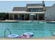 The Annandale community swimming pool with multiple swimmers and lounge chairs with a covered patio in background at 525 Glenkirk Pl, Garner, NC 27529