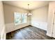 Elegant dining room with wainscoting, a modern chandelier, wood floors, and a large window with backyard views at 55 Capeside Ct, Lillington, NC 27546