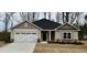 Charming single-story home with a two-car garage, neutral siding, stone accents, and a well-manicured lawn at 55 Capeside Ct, Lillington, NC 27546