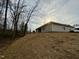 A view of the home's exterior, showing its placement on a lot with natural surroundings and a gently sloping hill at 55 Capeside Ct, Lillington, NC 27546