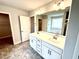 Bathroom with double sink vanity, a large mirror, gray tile flooring, and a tub in the background at 31 Capeside Ct, Lillington, NC 27546