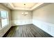Dining room with gray wood floors, tray ceilings, and large windows providing ample natural light at 31 Capeside Ct, Lillington, NC 27546