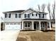 Charming two-story home with gray siding, a two-car garage, and a welcoming front porch at 31 Capeside Ct, Lillington, NC 27546