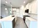 Modern kitchen boasts white cabinets, stainless appliances, and a large center island for meal prep and dining at 31 Capeside Ct, Lillington, NC 27546