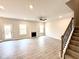 Spacious living room featuring gray wood floors, a fireplace, and staircase at 31 Capeside Ct, Lillington, NC 27546