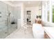 Bright bathroom with a large walk-in marble shower, standalone tub, and gold hardware at 144 W Beech Slope Ct, Chapel Hill, NC 27517