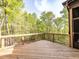 Spacious wooden deck with black metal railings and lush green trees in the background for a relaxing outdoor space at 144 W Beech Slope Ct, Chapel Hill, NC 27517