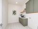 Functional laundry room with gray cabinets, a sink, a countertop, and stylish flooring at 144 W Beech Slope Ct, Chapel Hill, NC 27517