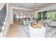 Open-concept living room with hardwood floors, neutral decor, and seamless flow to kitchen and outdoor living area at 144 W Beech Slope Ct, Chapel Hill, NC 27517