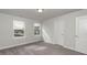Bedroom features neutral paint and carpet, two large windows, and two entry doors at 19 Streamline Ct, Lillington, NC 27546