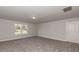Bonus room featuring neutral carpet and paint, a large window, and one entry door at 19 Streamline Ct, Lillington, NC 27546