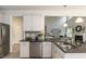 Contemporary kitchen featuring white cabinets, dark countertops, stainless steel appliances, and seamless flow to living room at 19 Streamline Ct, Lillington, NC 27546