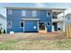 Backyard view of the home featuring a beautiful patio and blue siding at 417 E Moore St, Apex, NC 27502