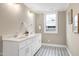 Bright bathroom featuring dual sinks, marble countertops, and unique flooring at 417 E Moore St, Apex, NC 27502