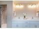 Bathroom with dual sinks, a sleek vanity, marble countertop, and a glass enclosed shower at 417 E Moore St, Apex, NC 27502