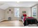 Comfortable bedroom featuring bright windows, neutral walls, and light wood flooring at 417 E Moore St, Apex, NC 27502