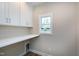 Bright laundry room with built-in shelves, white cabinets and a window at 417 E Moore St, Apex, NC 27502