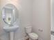 Elegant powder room with pedestal sink and oval mirror at 54 Barony Ln, Smithfield, NC 27577