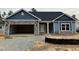 New construction home features blue siding, stone accents and a two-car garage in a residential neighborhood at 55 Streamline Ct, Lillington, NC 27546