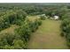 Expansive aerial view of a sprawling estate with lush greenery and stately white home at 1021 Dimmocks Mill Rd, Hillsborough, NC 27278