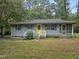Charming home with a bright yellow door, blue shutters, and a screened porch enhancing curb appeal at 1021 Dimmocks Mill Rd, Hillsborough, NC 27278