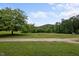 Well-manicured front yard showcasing the green lawn, garden, and distant hill at 1021 Dimmocks Mill Rd, Hillsborough, NC 27278