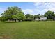 Expansive green front yard leading to a charming two-story home and verdant trees at 1021 Dimmocks Mill Rd, Hillsborough, NC 27278