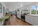 Bright kitchen featuring modern appliances, white cabinetry, and hardwood floors flowing into the dining area at 1021 Dimmocks Mill Rd, Hillsborough, NC 27278